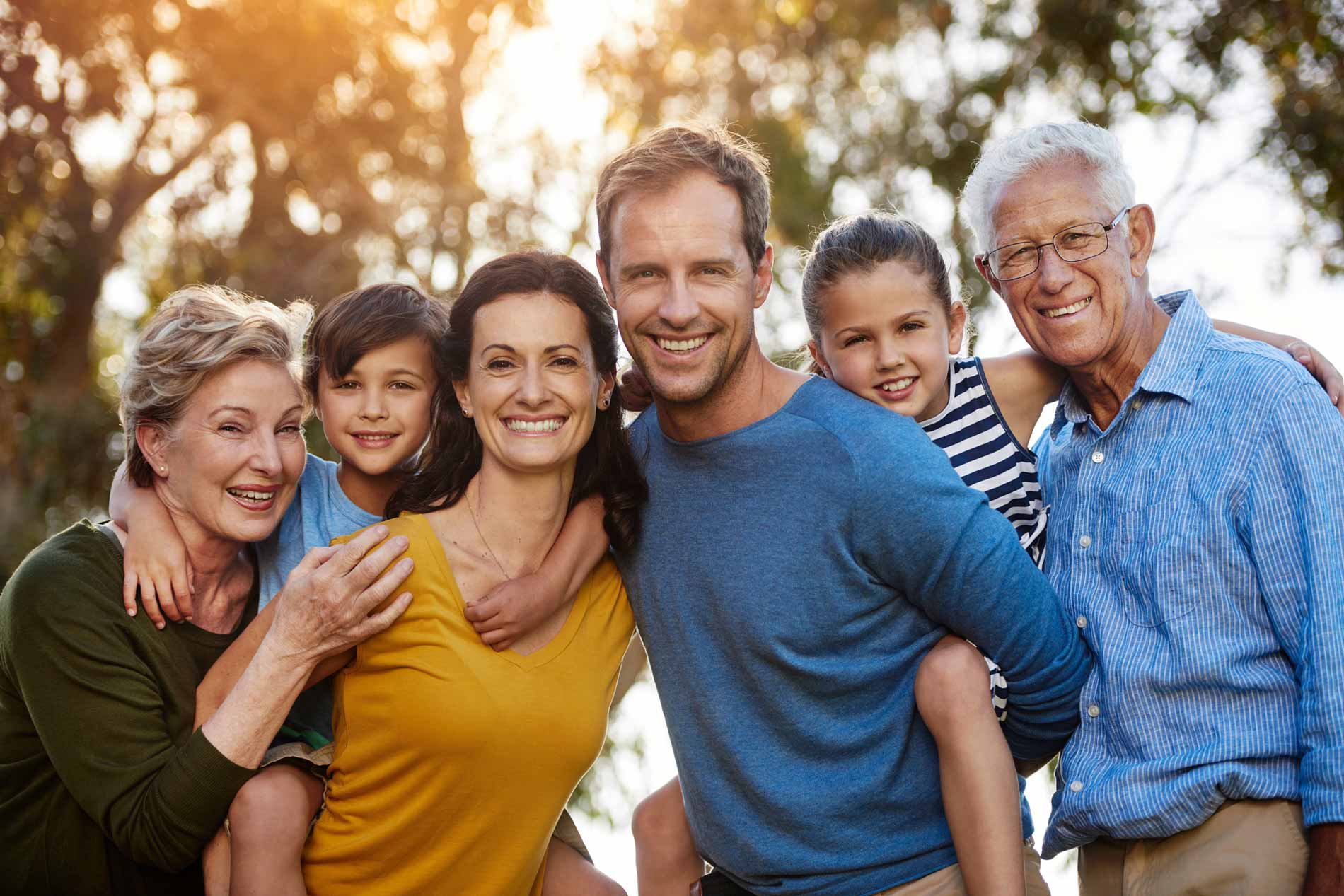 Multi-generational family posing together outside.